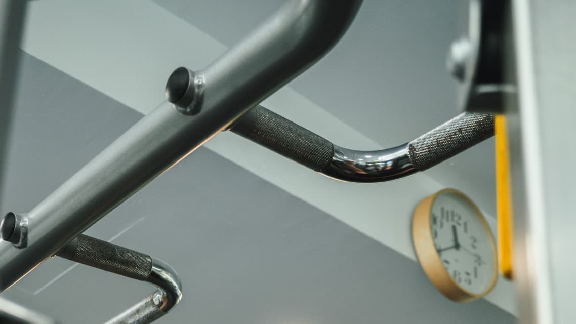 Strength-training handles and a wall clock in the Progressive Performance training space.