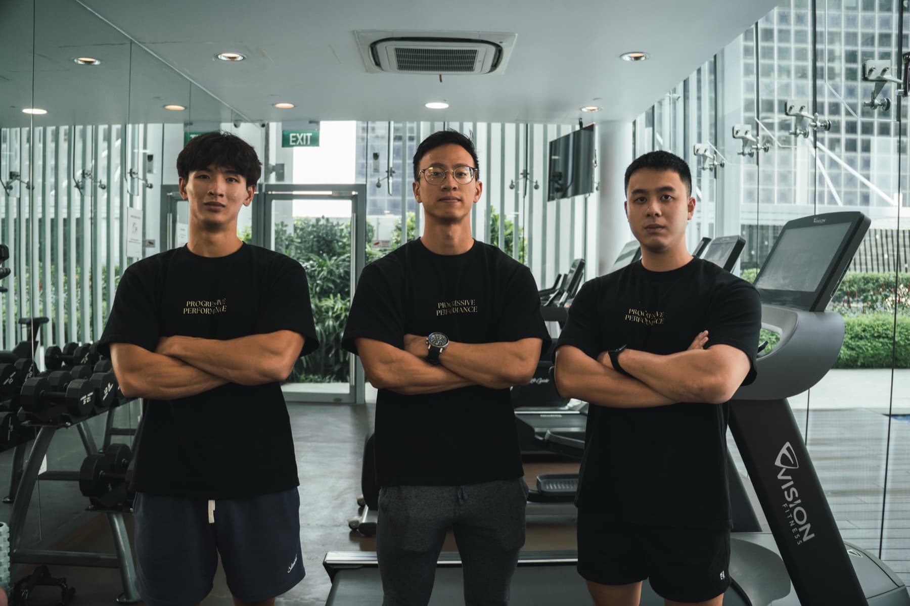 Three Progressive Performance coaches standing in a Singapore training studio.