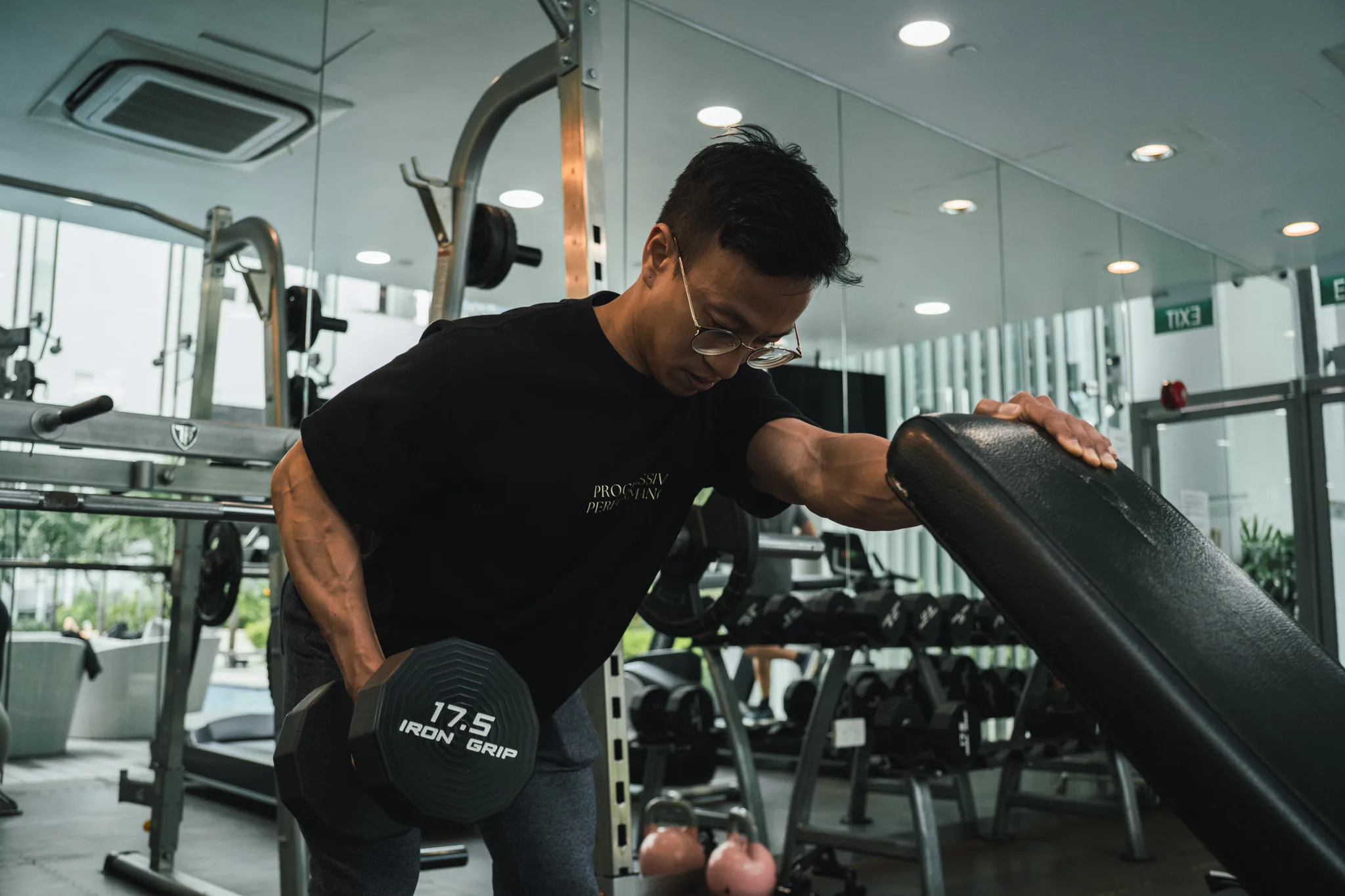 Progressive Performance team member performing a dumbbell row in the Singapore studio