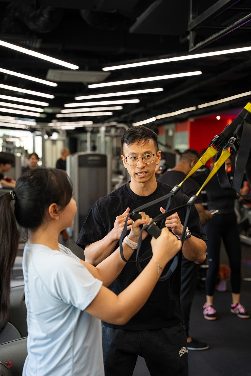 A Progressive Performance coach guiding a client on resistance equipment at the Shenton Way studio in Singapore.