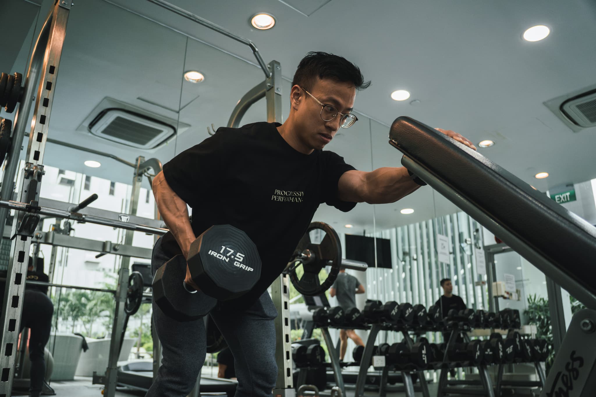 Progressive Performance coach demonstrating a dumbbell row in the studio