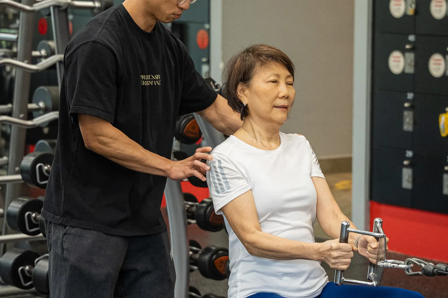 Leon guiding a client through a seated cable exercise