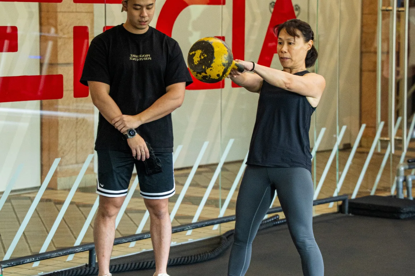 Kieran coaching a client through a kettlebell exercise