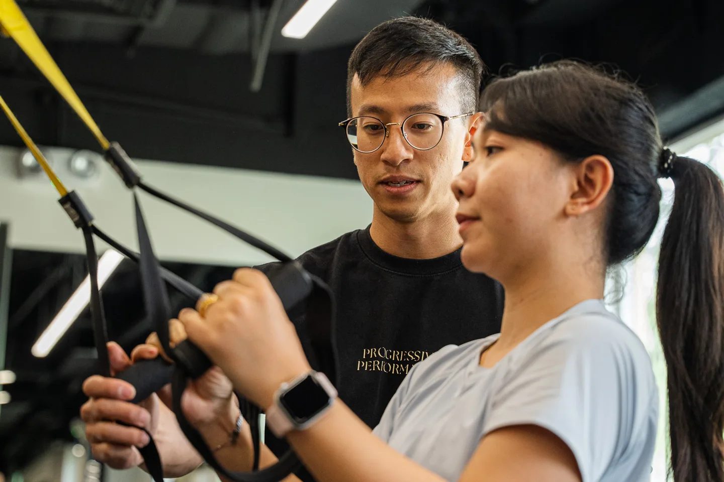 Leon coaching a client through a suspension exercise