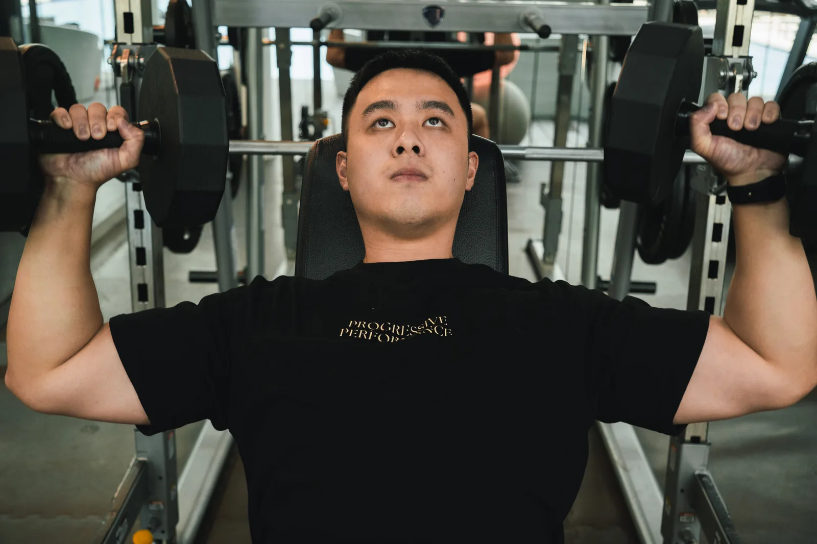 Kieran training with dumbbells at Progressive Performance