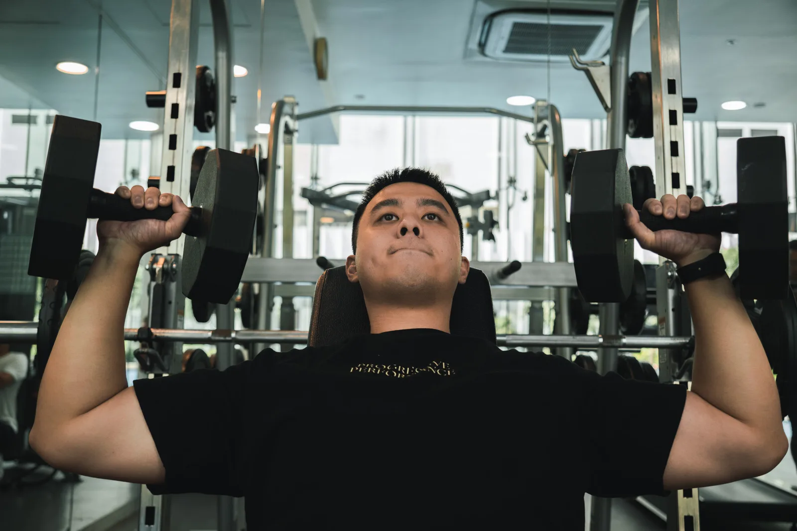 Kieran performing a dumbbell press at the private gym